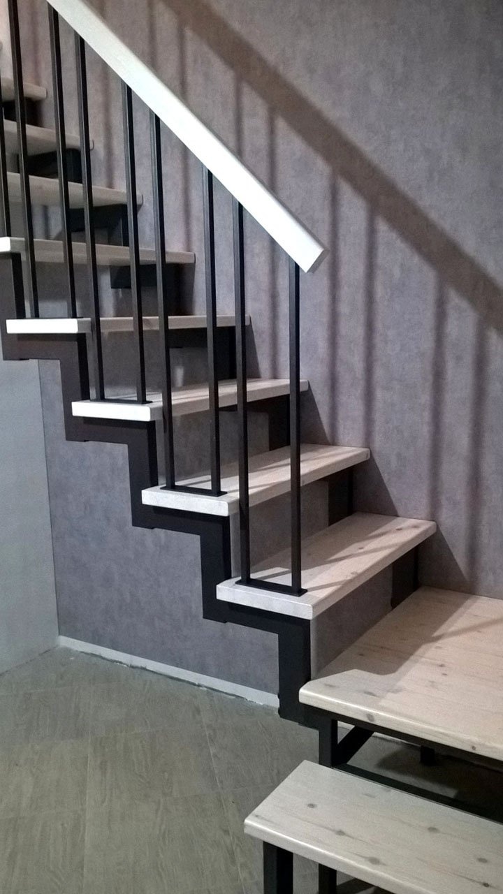 Лестница на двух косоурах с белыми ступенями и поручнем, вид сбоку
